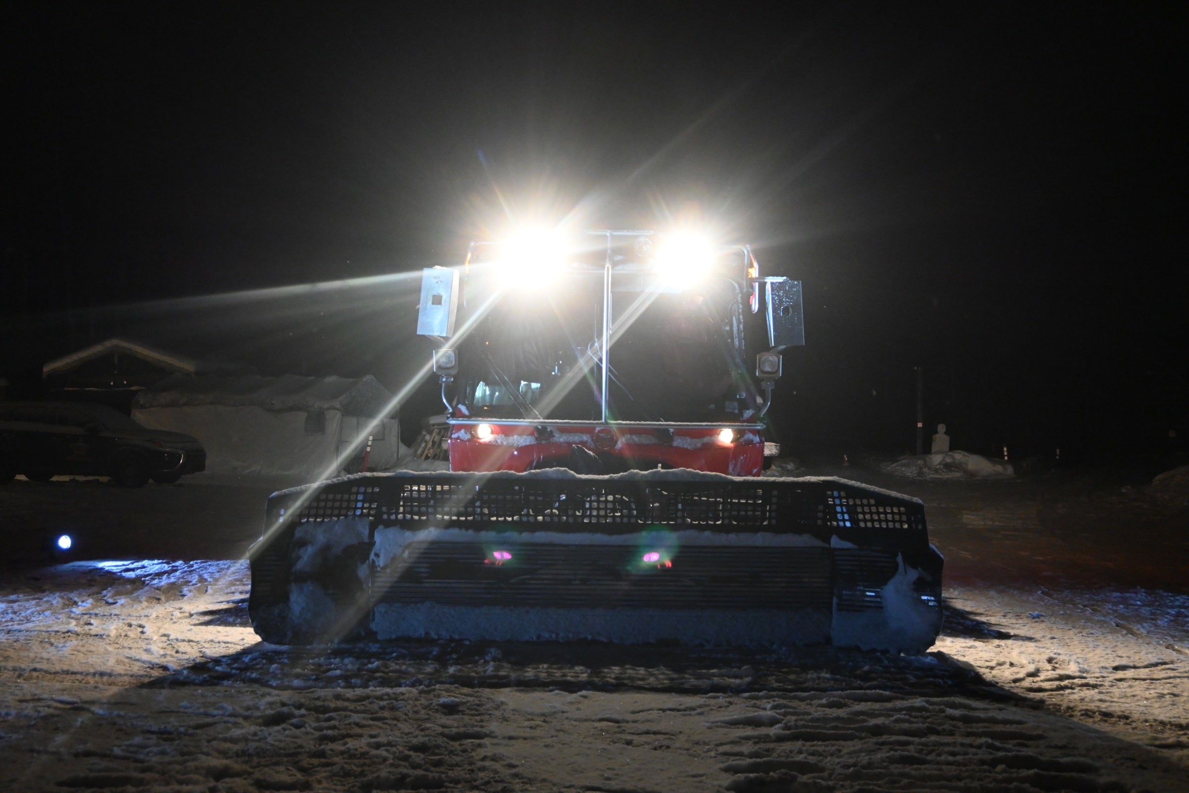 BR trail groomer illuminated from the front during nighttime maintenance